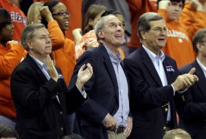 Sen. Lindsay Graham, former Sen. Daniel Coats, and former Sen. Trent Lott, from left, react during the first half.