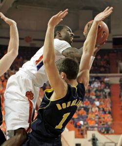Driving under the basket for a shot, Clemson's Demontez Stitt, center back, is fouled by Michigan's Stu Douglass (1) in the first half of their NCAA basketball game at Littlejohn Coliseum in Clemson, S.C. on Tuesday, Nov. 30, 2010. (AP Photo/Anderson Independent-Mail, Mark Crammer)