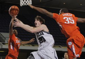 Butler's Gordon Hayward, center, drives to the basket against Clemson's Demontez Stitt, left, and Trevor Booker during the first half of an NCAA college basketball game in the 76 Classic in Anaheim, Calif., Sunday, Nov. 29, 2009.