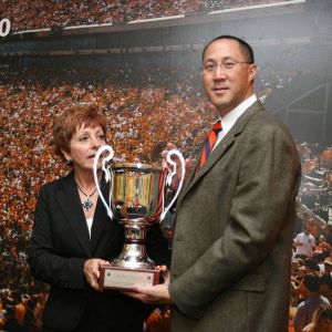 Head Coach Chris Ip with Director of Community Relations Linda White and the President's Cup Trophy