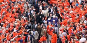 Clemson interim head coach Dabo Swinney acknowledges the crowd as he leads his team through a crowd of supporters before the game.