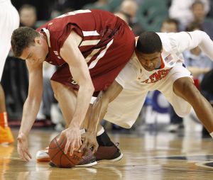 Boston College's Joe Trapani, left, and Clemson's Devin Booker, right, scramble for a loose ball in the first half of an NCAA college basketball game at the Atlantic Coast Conference tournament in Greensboro, N.C., Friday, March 11, 2011. (AP Photo/Bob Leverone)