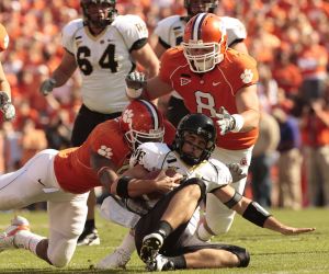 Kourtnei Brown, left, and Jamie Cumbie, (8), right, converge to make a tackle on Wake Forest quarterback Riley Skinner, (11) during the first quarter. (AP Photo/ Patrick Collard)