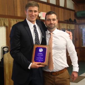 Associate Head Coach Philip Jones presents the Ratchford Coach's Achievement Award to Bobby Belair